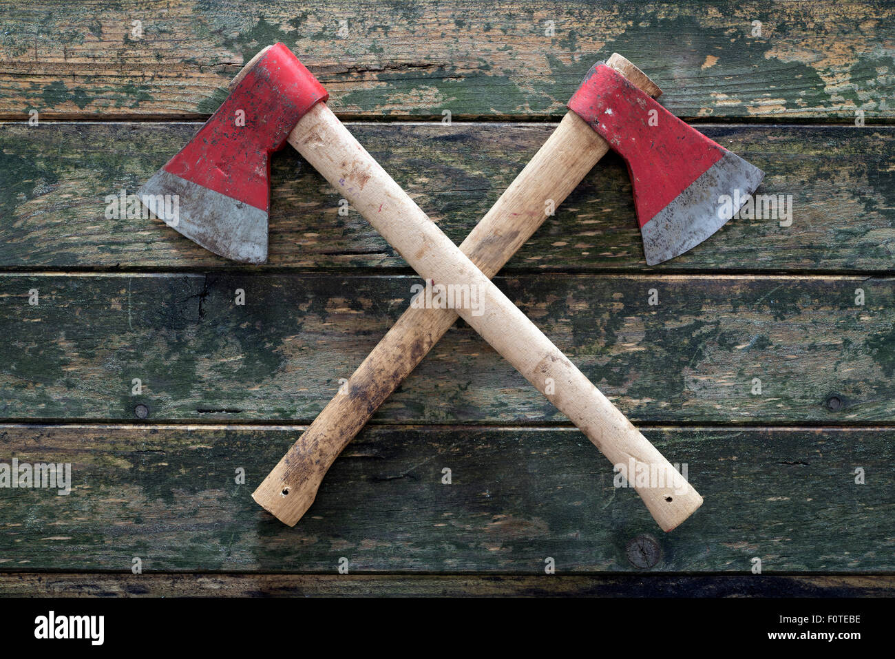 zwei gekreuzte Achsen auf einem hölzernen Hintergrund Stockfoto