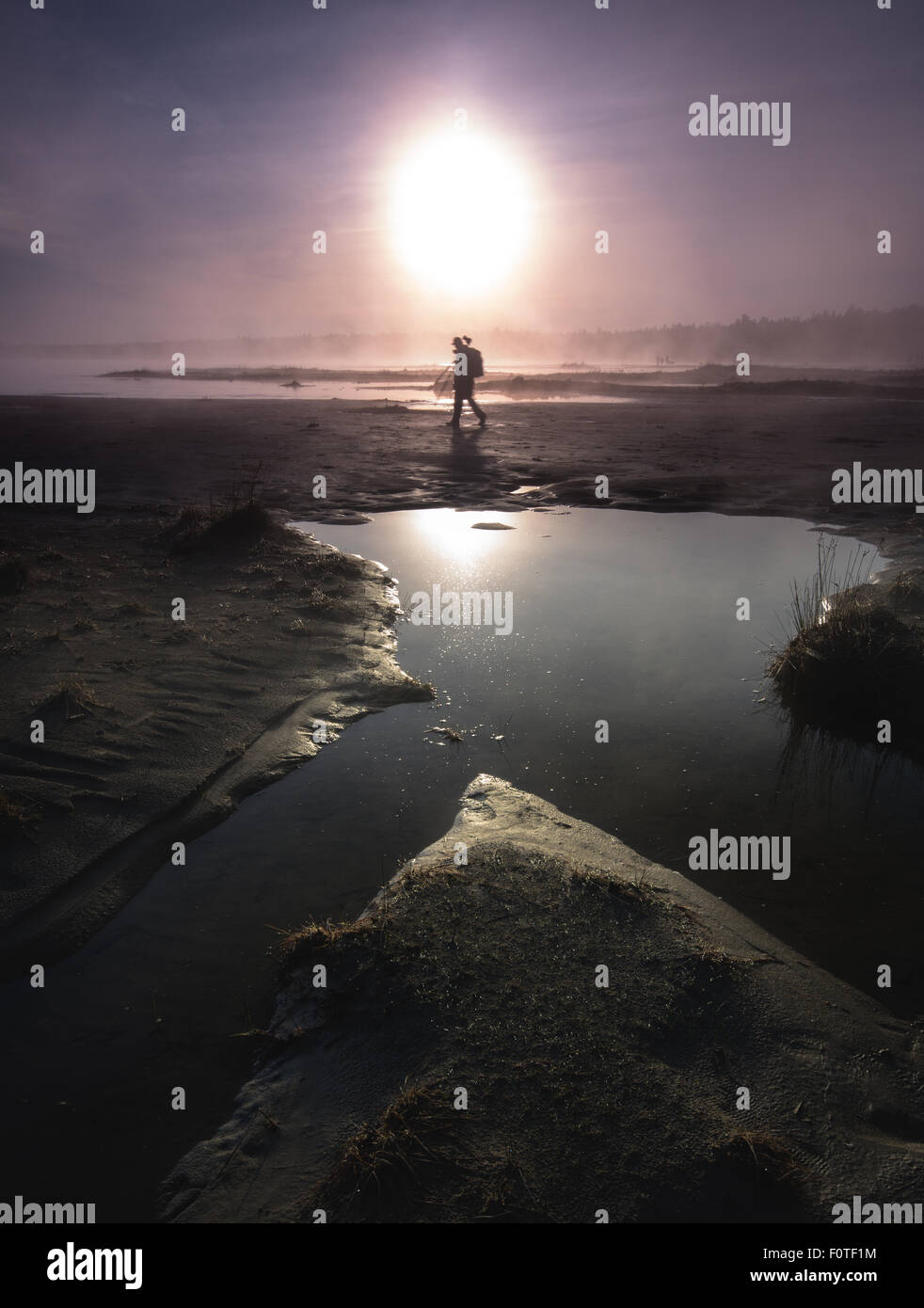 Nick auf der Suche nach einem Winkel auf den nebeligen Sonnenuntergang am Singing Sands Beach in Tobermory, Ontario, Kanada. Stockfoto Nick auf der Suche nach einem Winkel auf den nebeligen Sonnenuntergang am Singing Sands Beach in Tobermory, Ontario, Kanada. Stockfoto