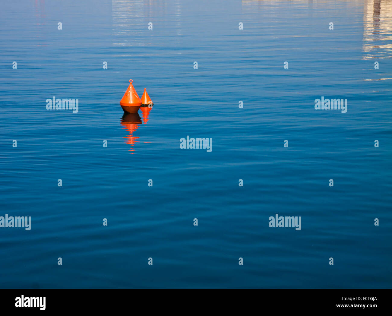 Meer Hintergrund, ruhiges Wasser und zwei roten Bojen schwimmen und Nachdenken über das tiefblaue Wasser Stockfoto