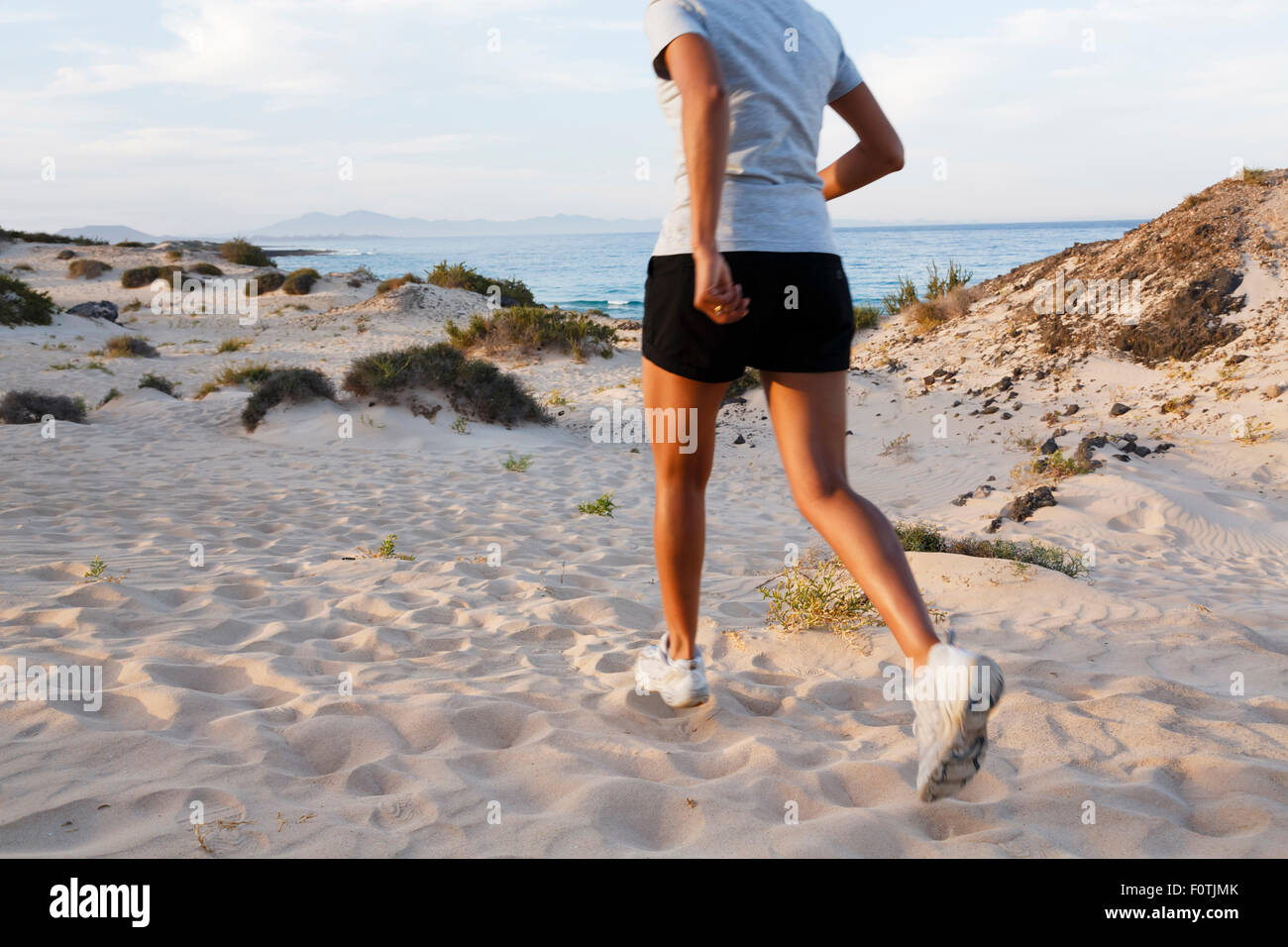 Weibliche indische Jogger jogging am Strand Stockfoto