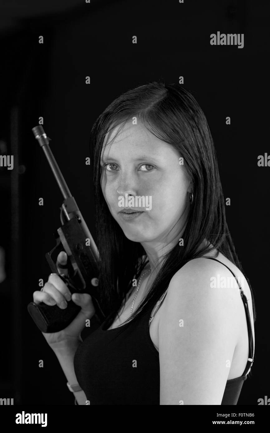 Mädchen posiert mit Handfeuerwaffe am Festplatz Schießbude. Stockfoto