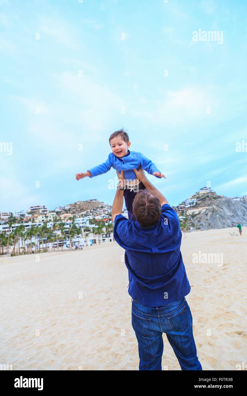 Anhebende Sohn Vater, am Strand, Rückansicht Stockfoto