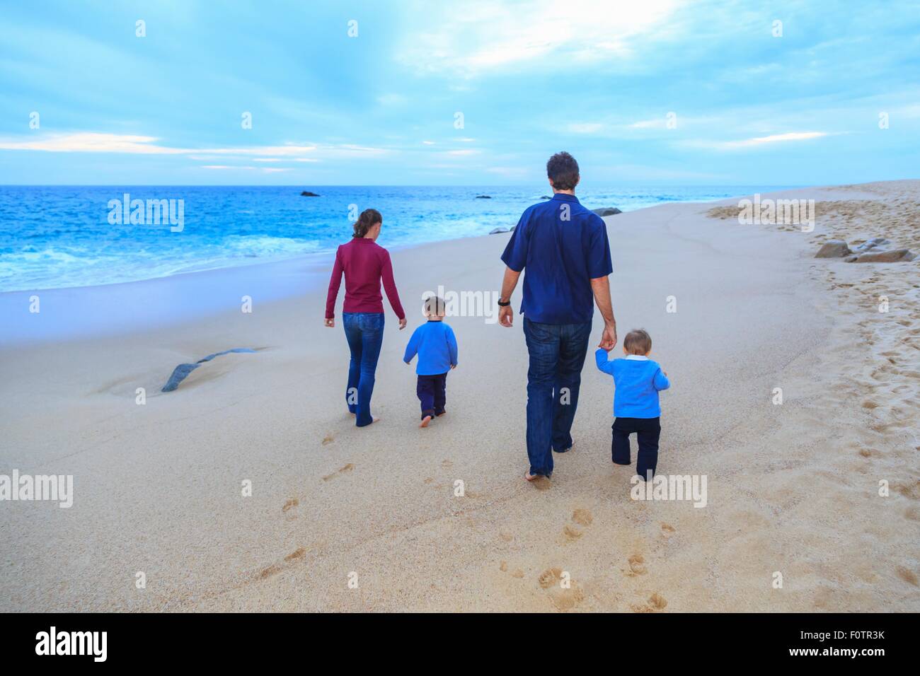 Junge Familie, die zu Fuß am Strand, Rückansicht Stockfoto