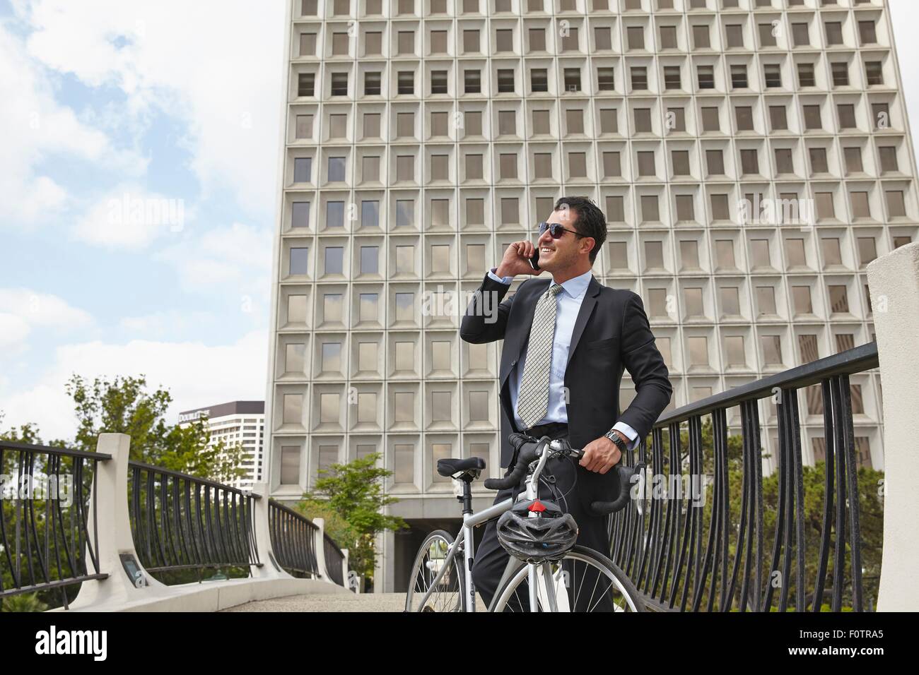 Mitte adult Business-Mann mit Fahrrad, Telefongespräch mit Smartphone das Tragen von Sonnenbrillen Stockfoto