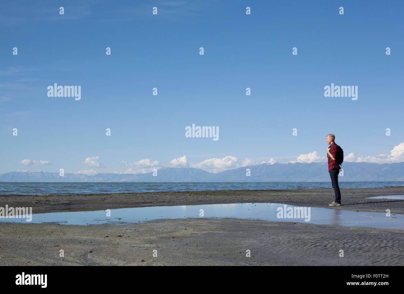 Seitenansicht der junge Mann, der am Rand des Wassers Ausschau, Great Salt Lake City, Utah, USA Stockfoto