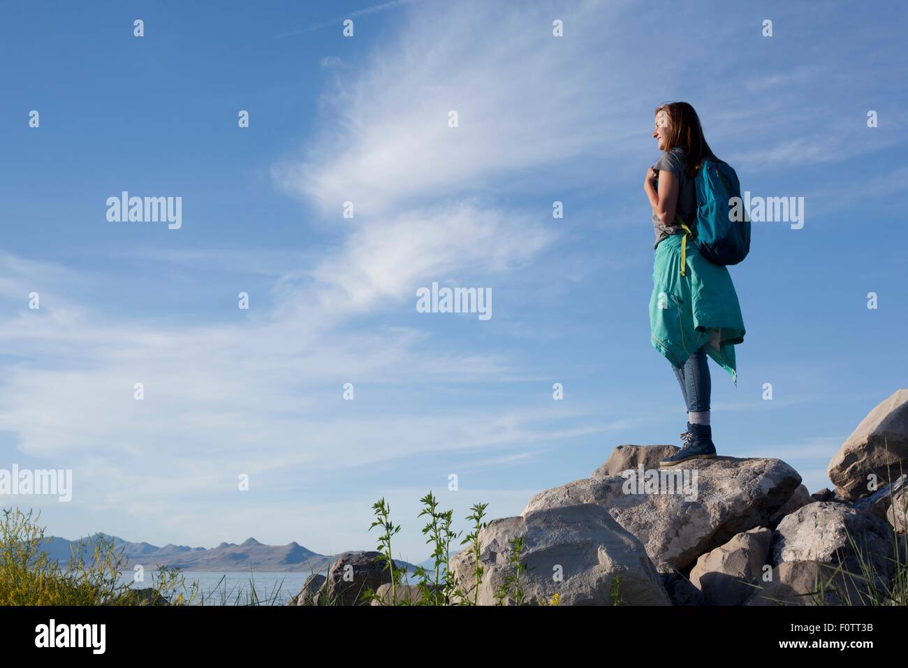 Rückansicht des jungen Frau mit Rucksack stehen auf Felsen wegsehen, Great Salt Lake City, Utah, USA Stockfoto