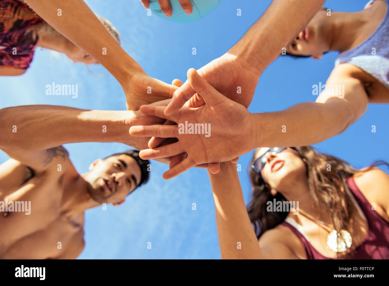 Gruppe von Freunden, die Hand in Hand am Strand, niedrigen Winkel Ansicht Stockfoto