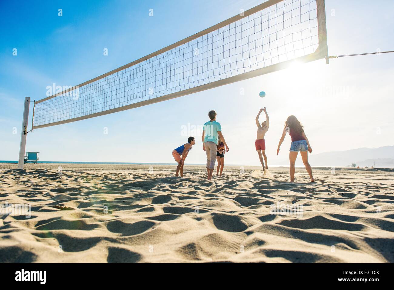 Gruppe von Freunden, die am Strand Volleyball spielen Stockfoto