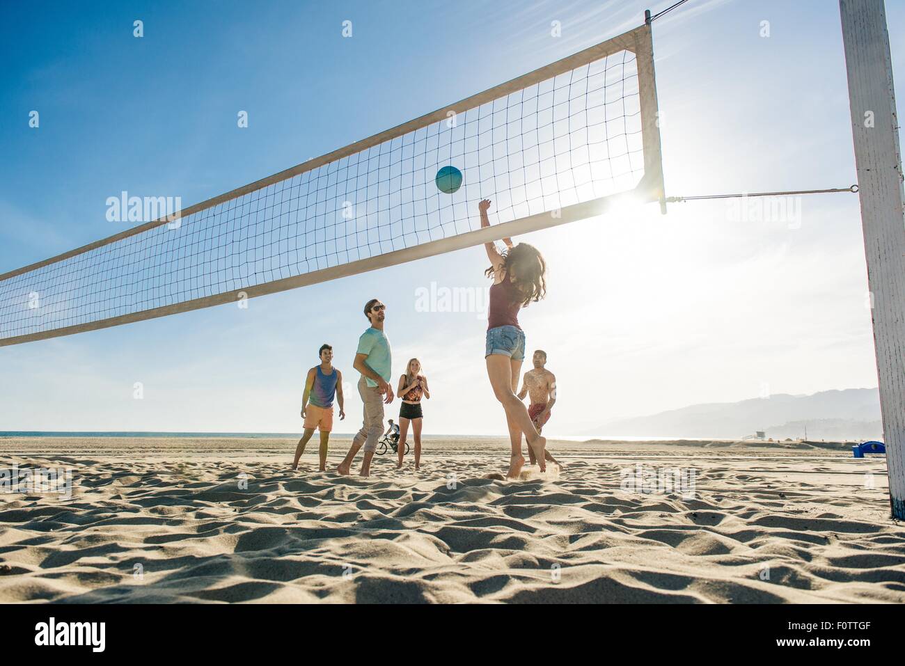 Gruppe von Freunden, die am Strand Volleyball spielen Stockfoto