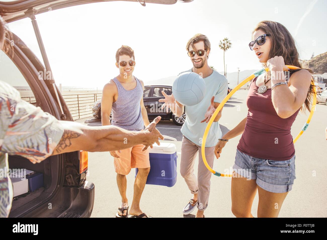 Gruppe von Freunden mit dem Auto stehen, Picknick und spielen Elemente halten Stockfoto