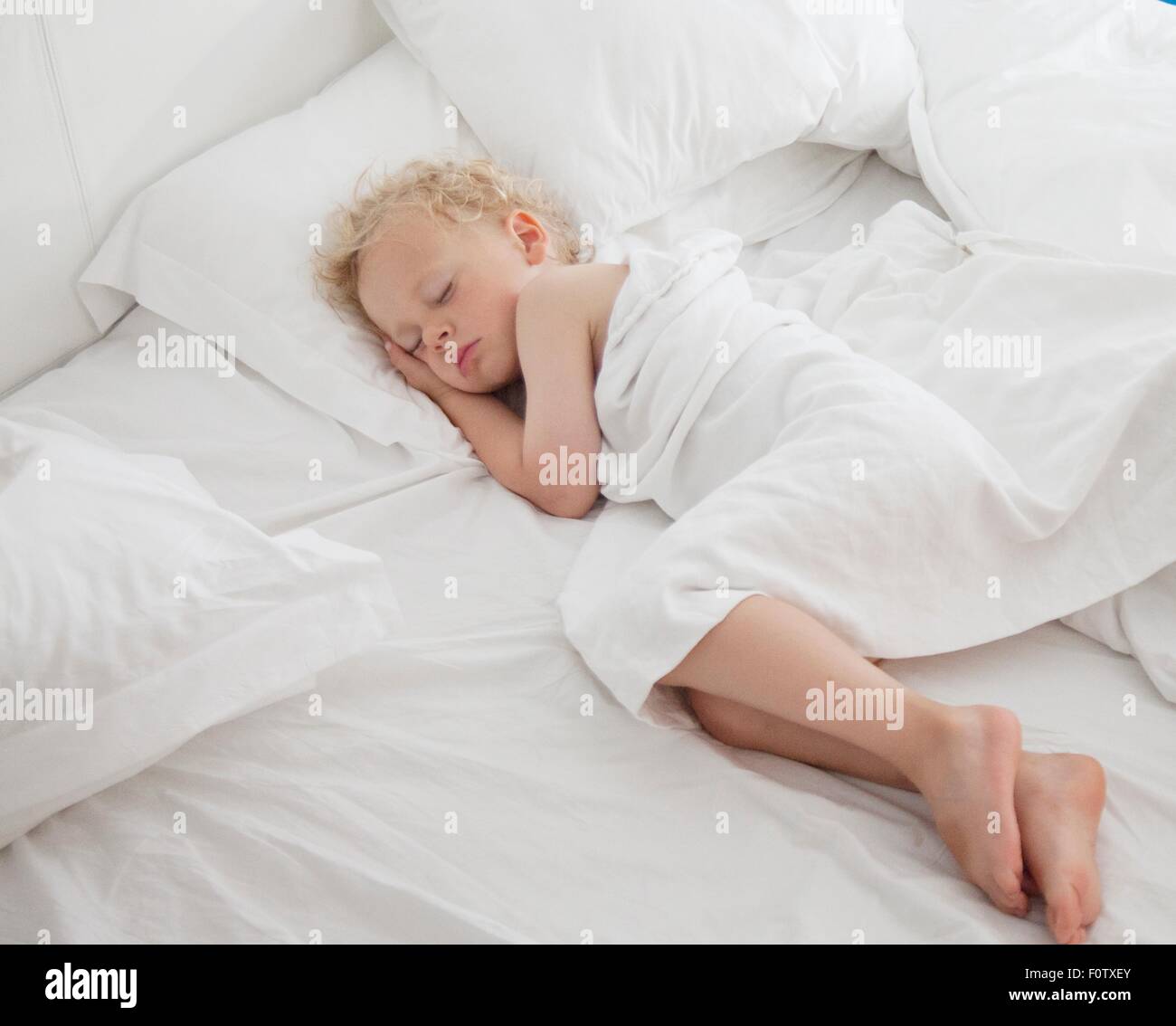 Kleiner Junge schlafend im Bett, unter dem Deckmantel Stockfoto