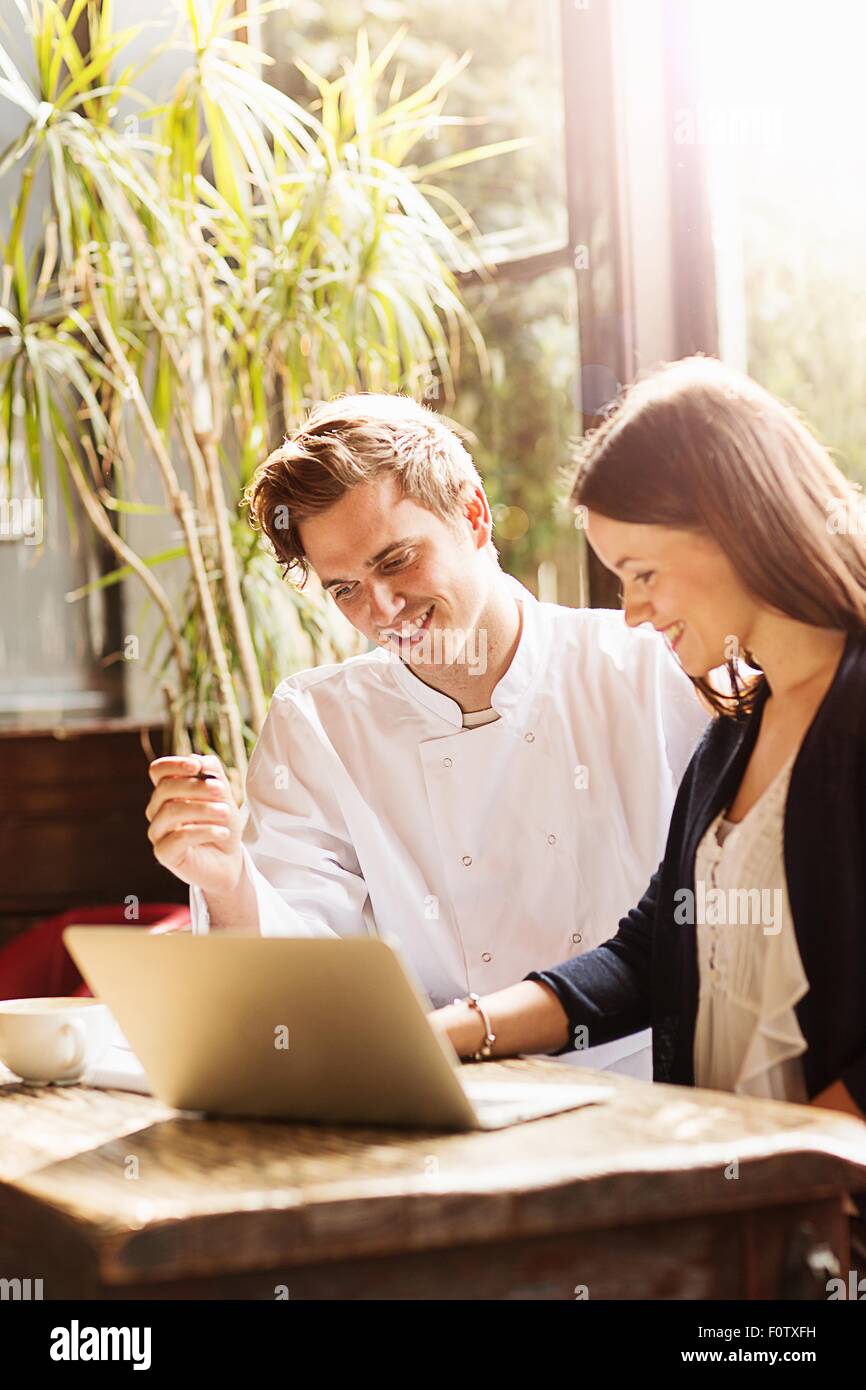 Paar bei der Arbeit in Bar mit Laptop Stockfoto