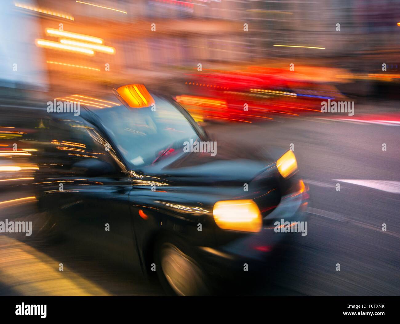 Schwarzes Taxi Bewegung verwischt in der Abenddämmerung, London, Uk Stockfoto