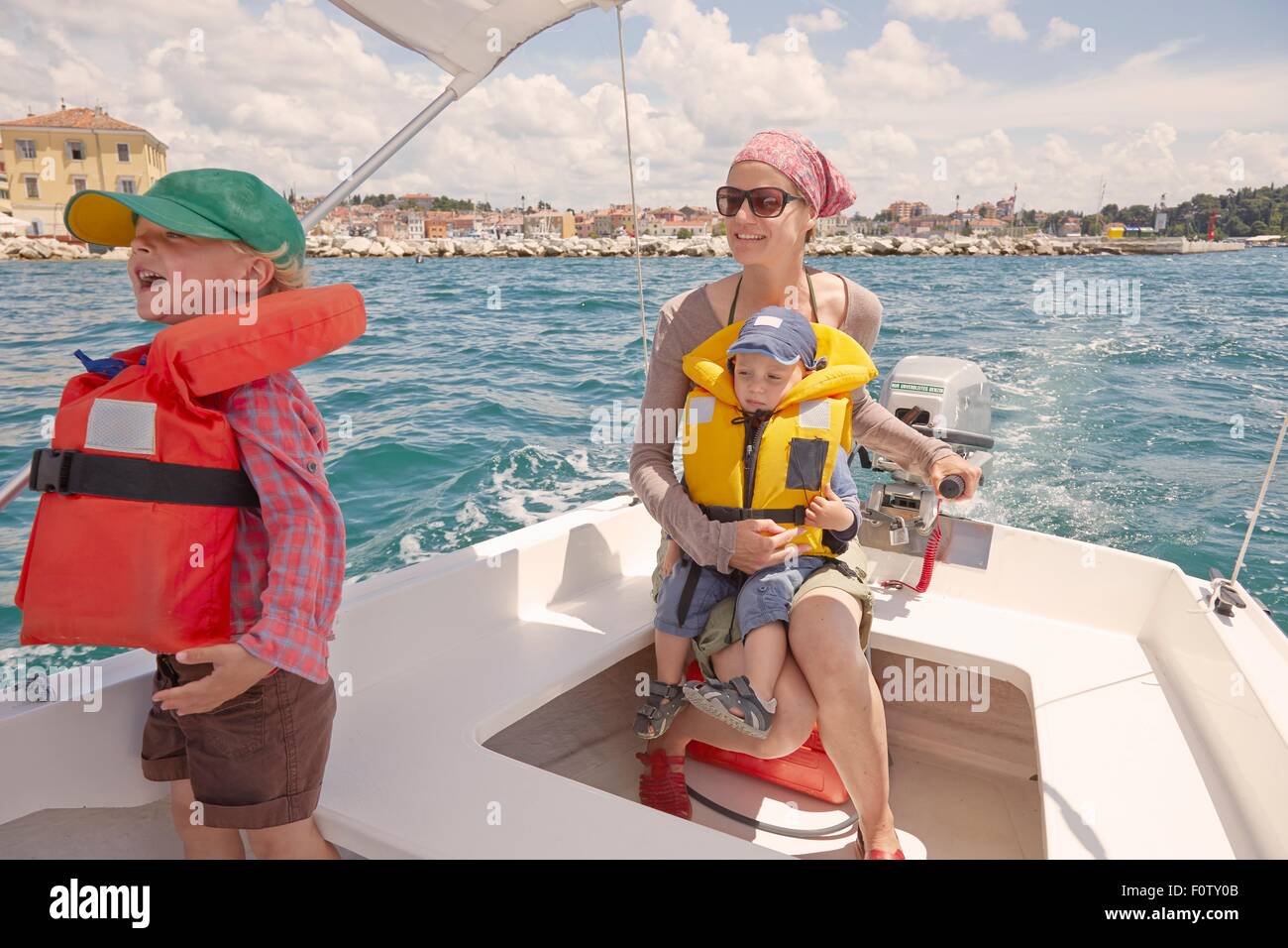 Reife Frau mit zwei jungen, die Lenkung Motorboot, Rovinj, Halbinsel Istrien, Kroatien Stockfoto