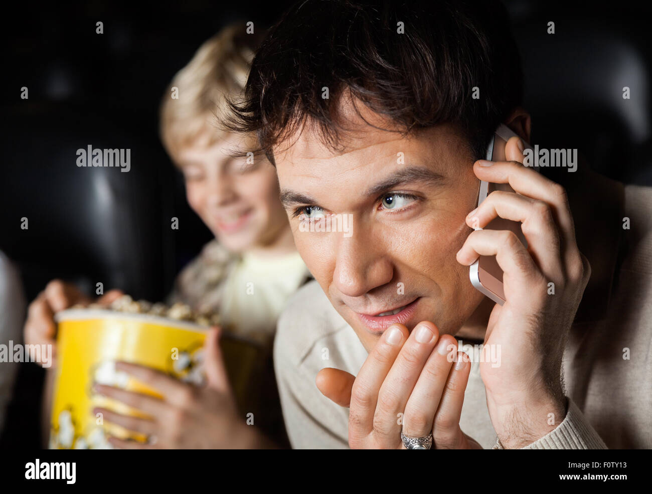 Mann mit Handy im Kino-Theater Stockfoto