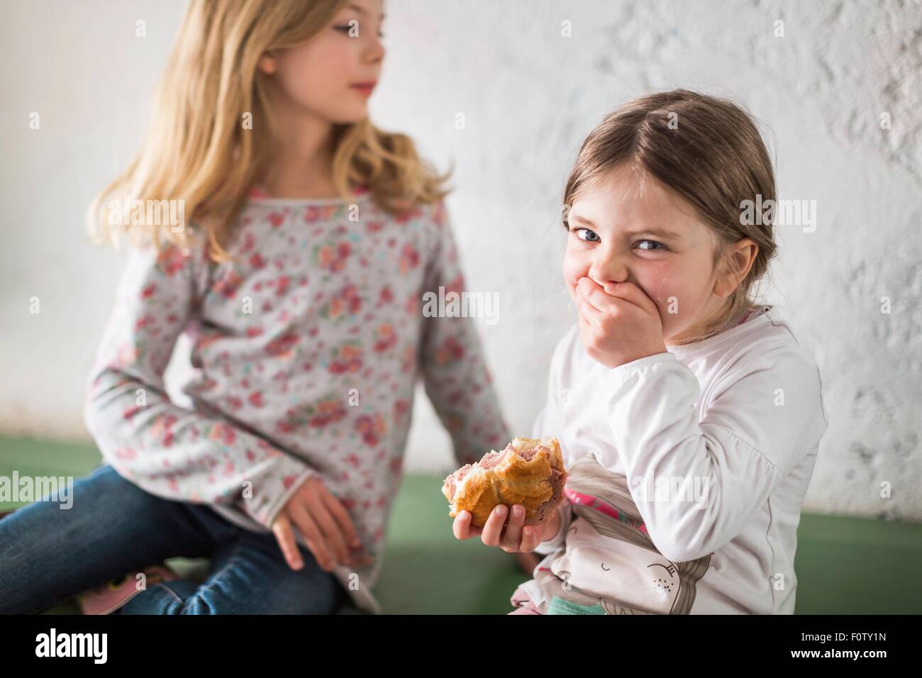 Zwei junge Mädchen essen herzhaft roll Stockfoto