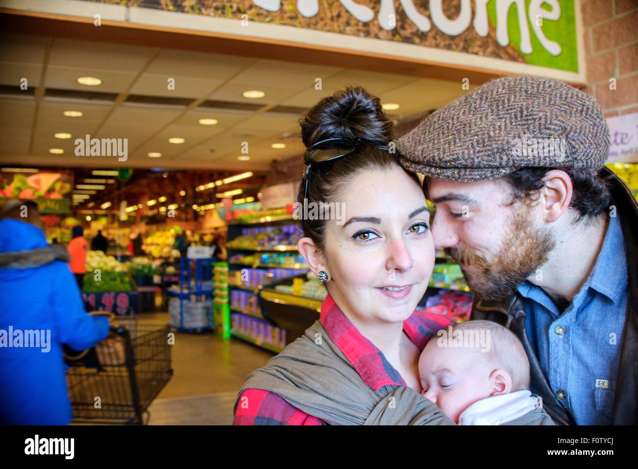 Mutter und Vater mit Sohn im Supermarkt Stockfoto