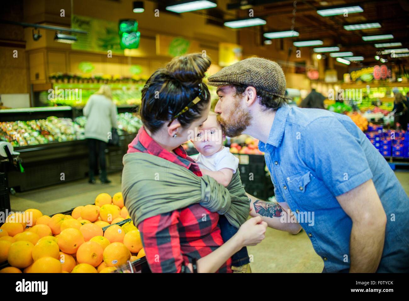 Vater küssen Baby Sohn im Supermarkt Stockfoto