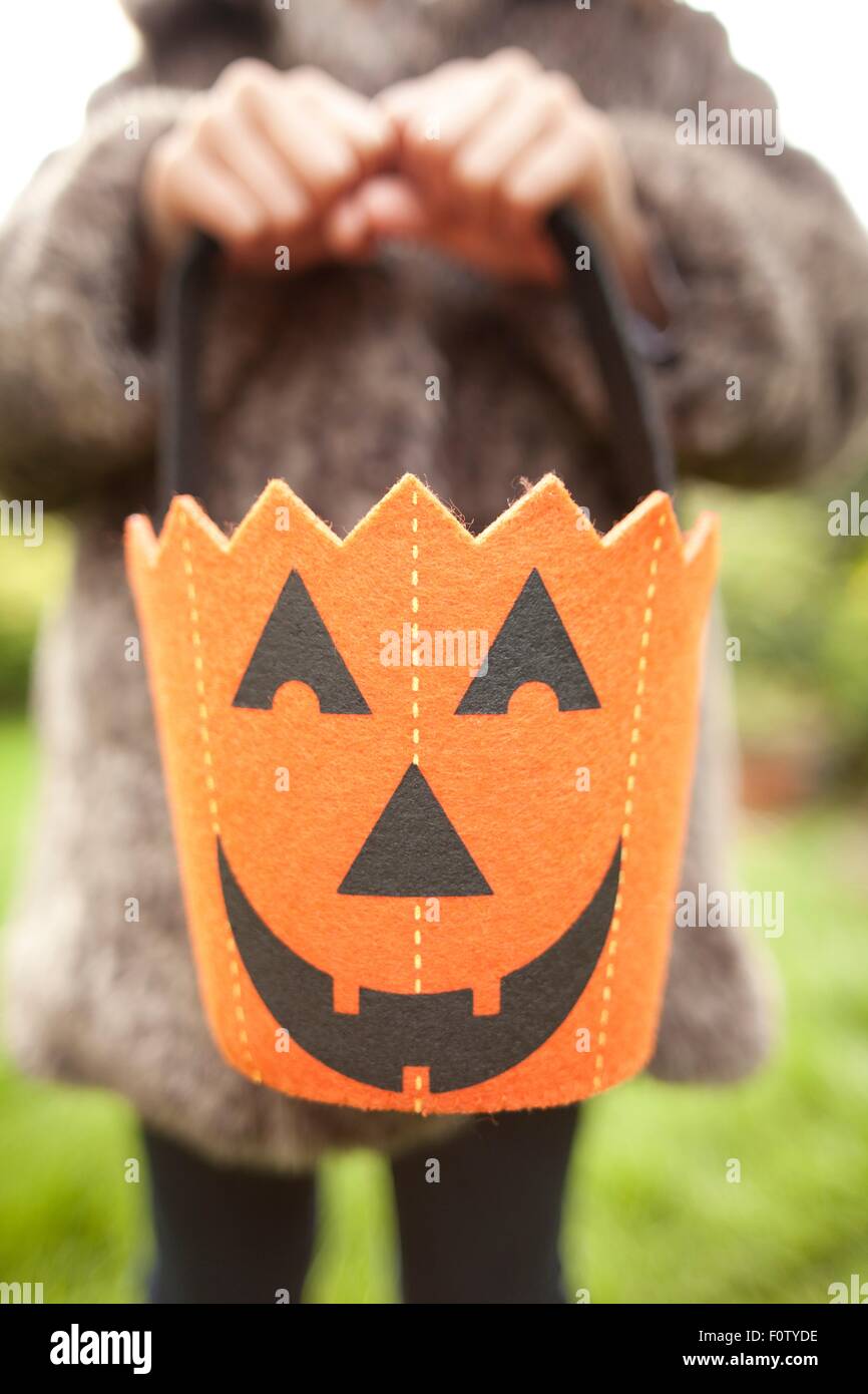 Mädchen hält Halloween Kürbis Tasche für Trick oder Behandlung von Stockfoto