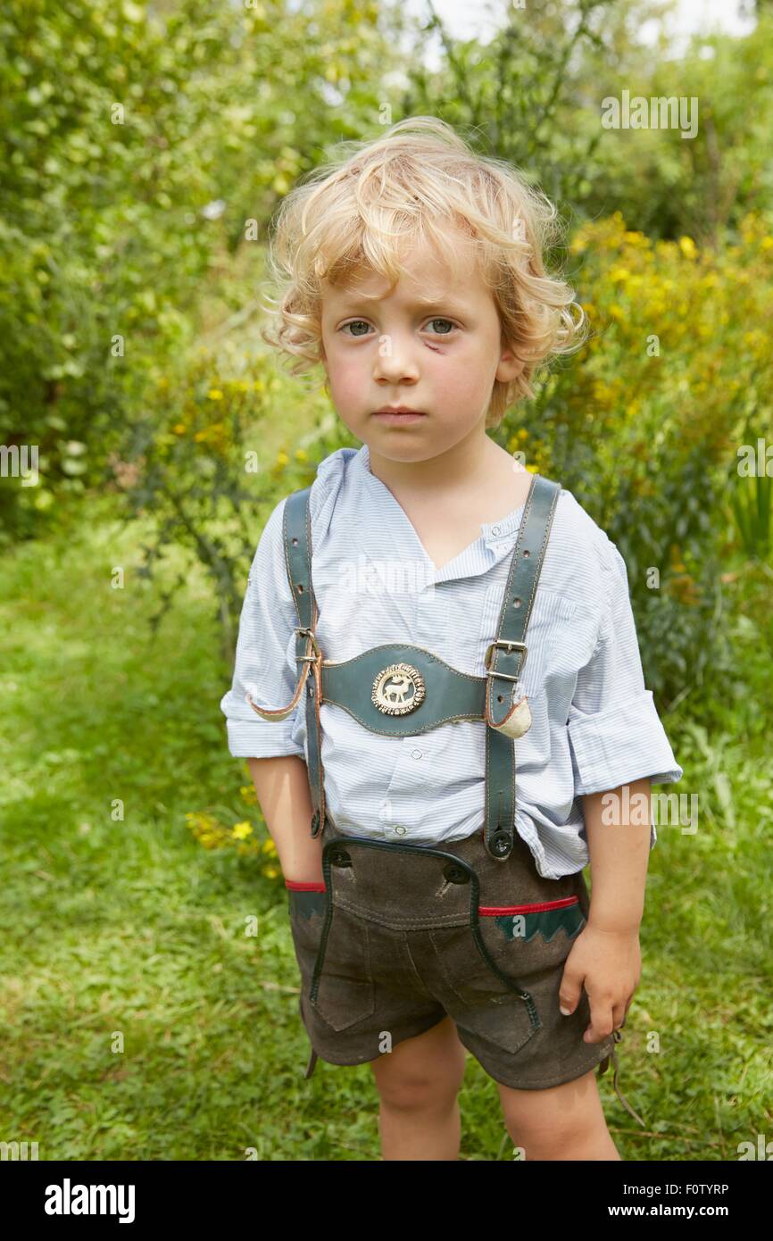 Porträt eines traurigen jungen mit zerkratzten Gesicht tragen lederhosen Stockfoto