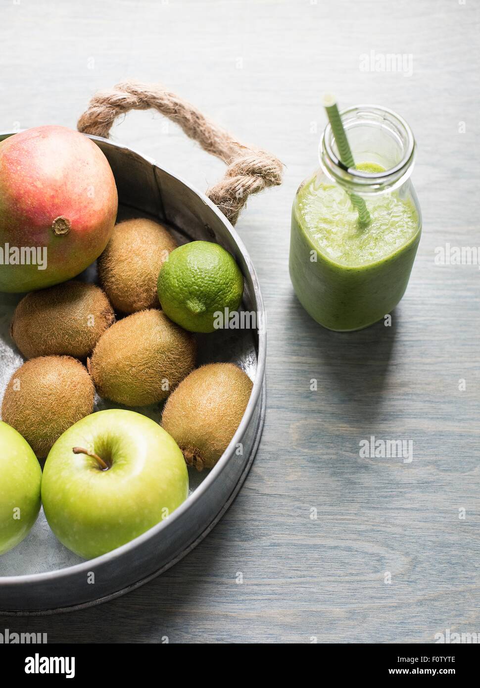 Glas mit frischen grünen Smoothie und Pfanne von Obst und Gemüse Stockfoto