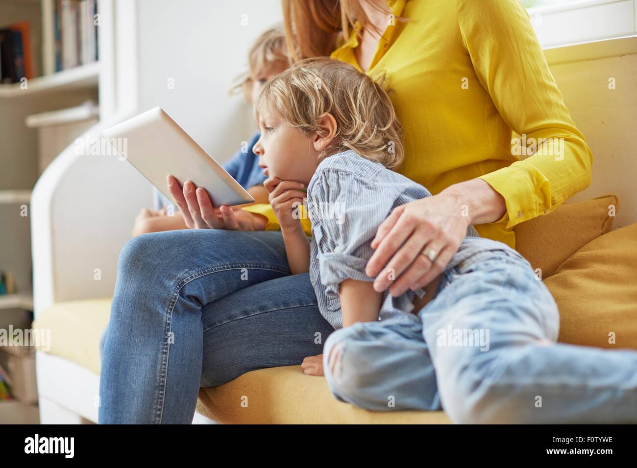 Mutter und zwei Söhne, Blick auf digital-Tablette, Mittelteil Stockfoto