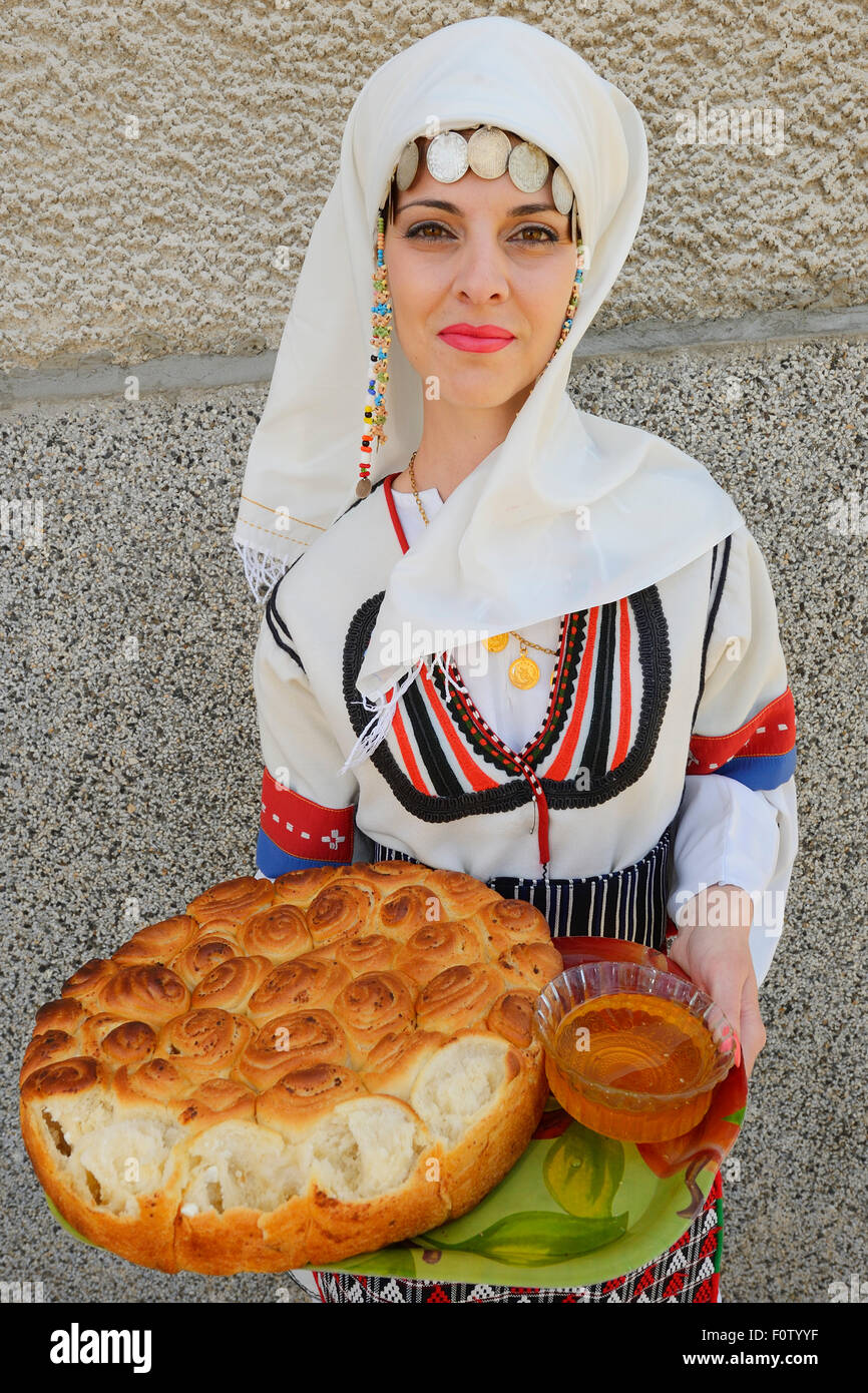 Junge Frau im Balkan Kleid mit Brot und Honig bei der Feier der Eröffnung eines neuen Werkes von Tahini-Produktion in Kondovo Dorf, östlichen Rhodopen Bulgarien Mai 2013. Stockfoto