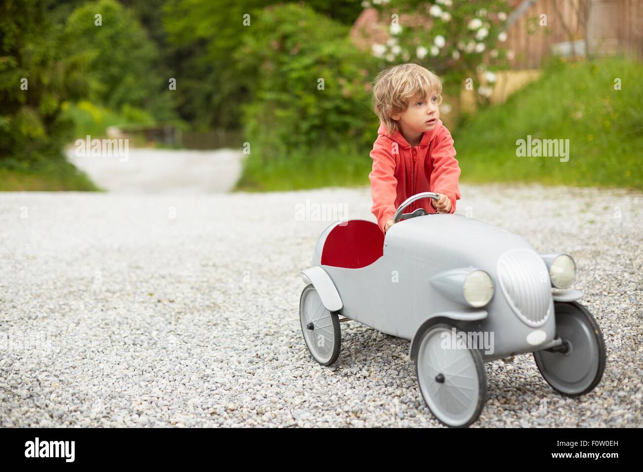 Jungen spielen mit Vintage Spielzeugauto im Freien, wegschauen Stockfoto