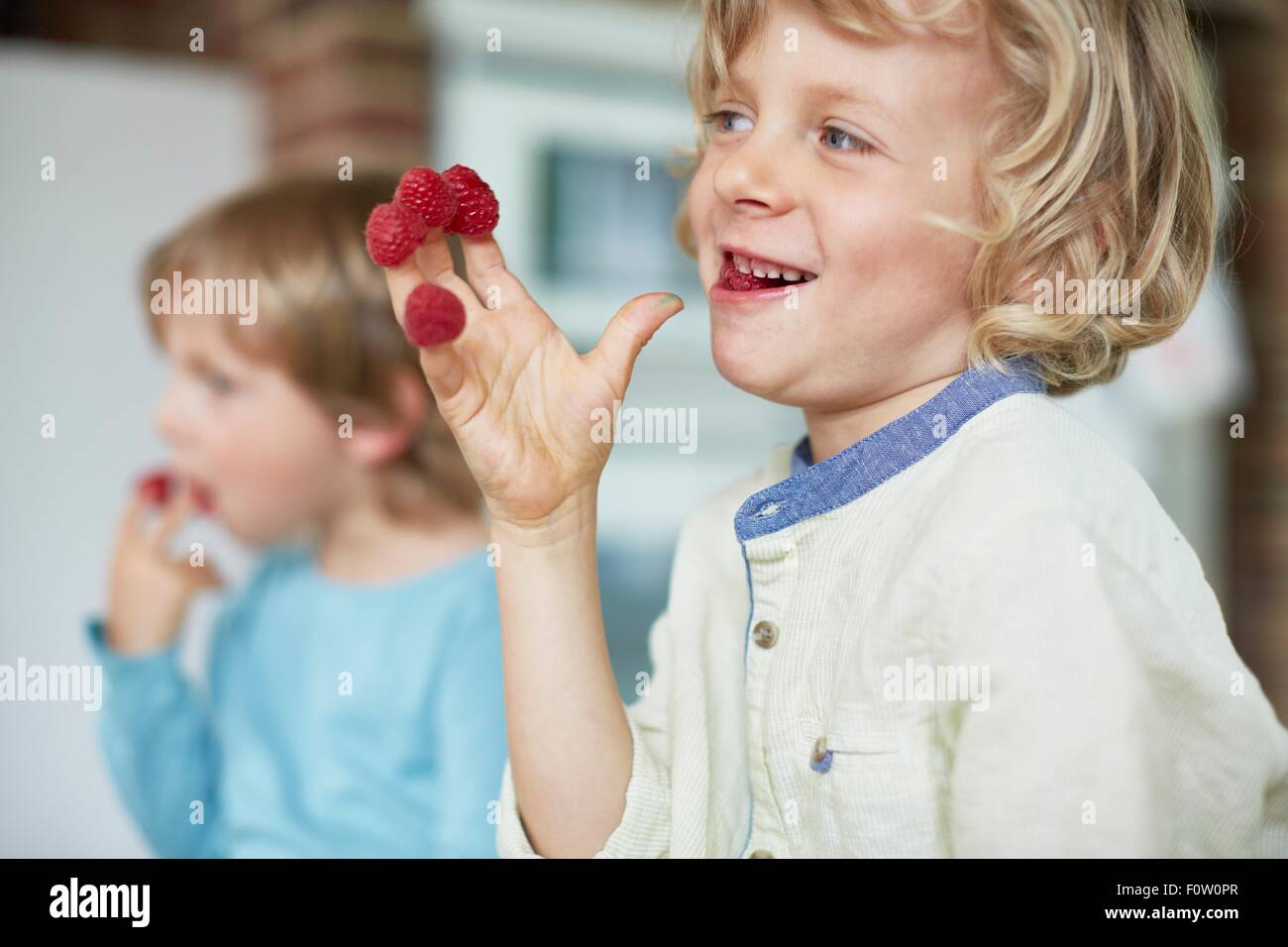 Zwei jungen Essen Himbeeren aus Fingerspitzen Stockfoto