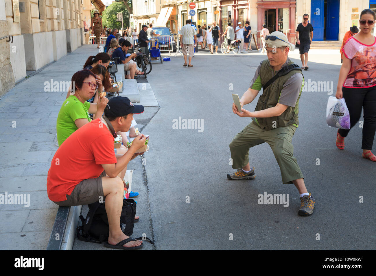 Asiatische Touristen fotografieren einander in Arles, Frankreich Stockfoto