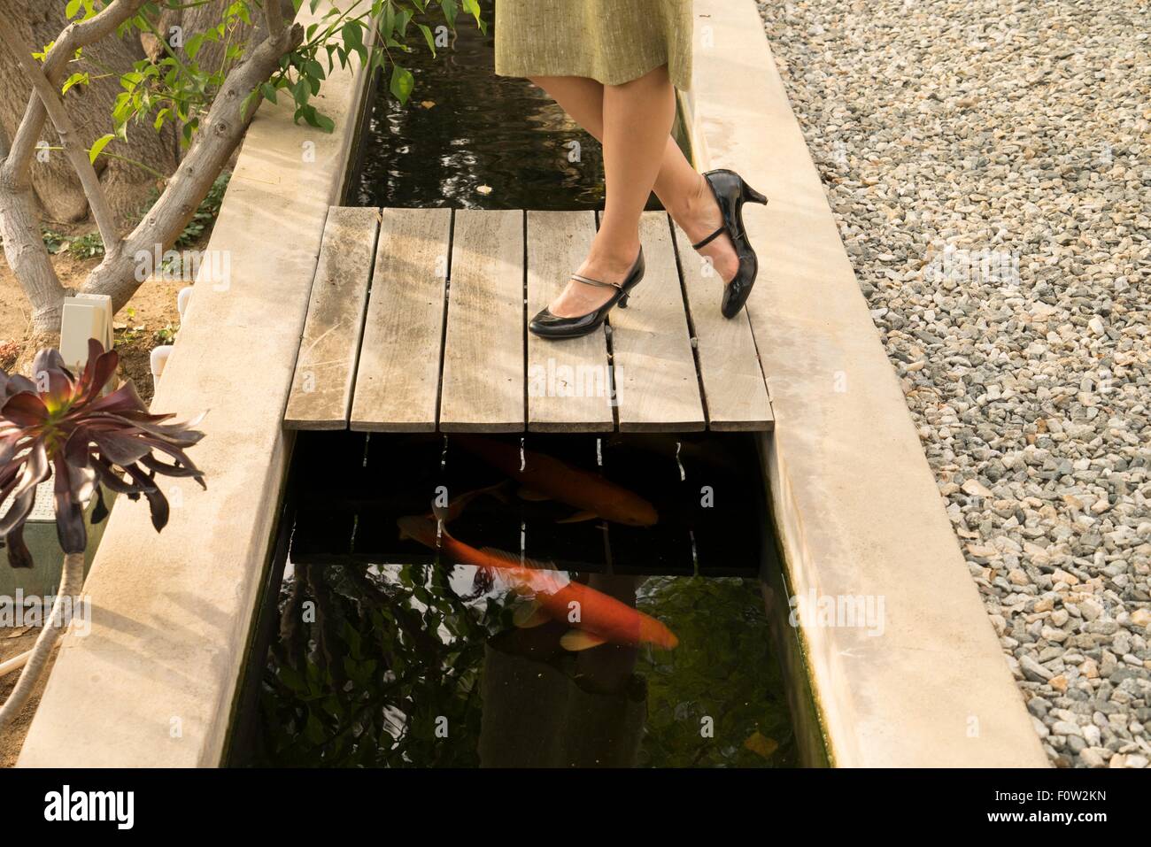 Beine Mitte erwachsenen Frau am Fischteich im Garten Stockfoto