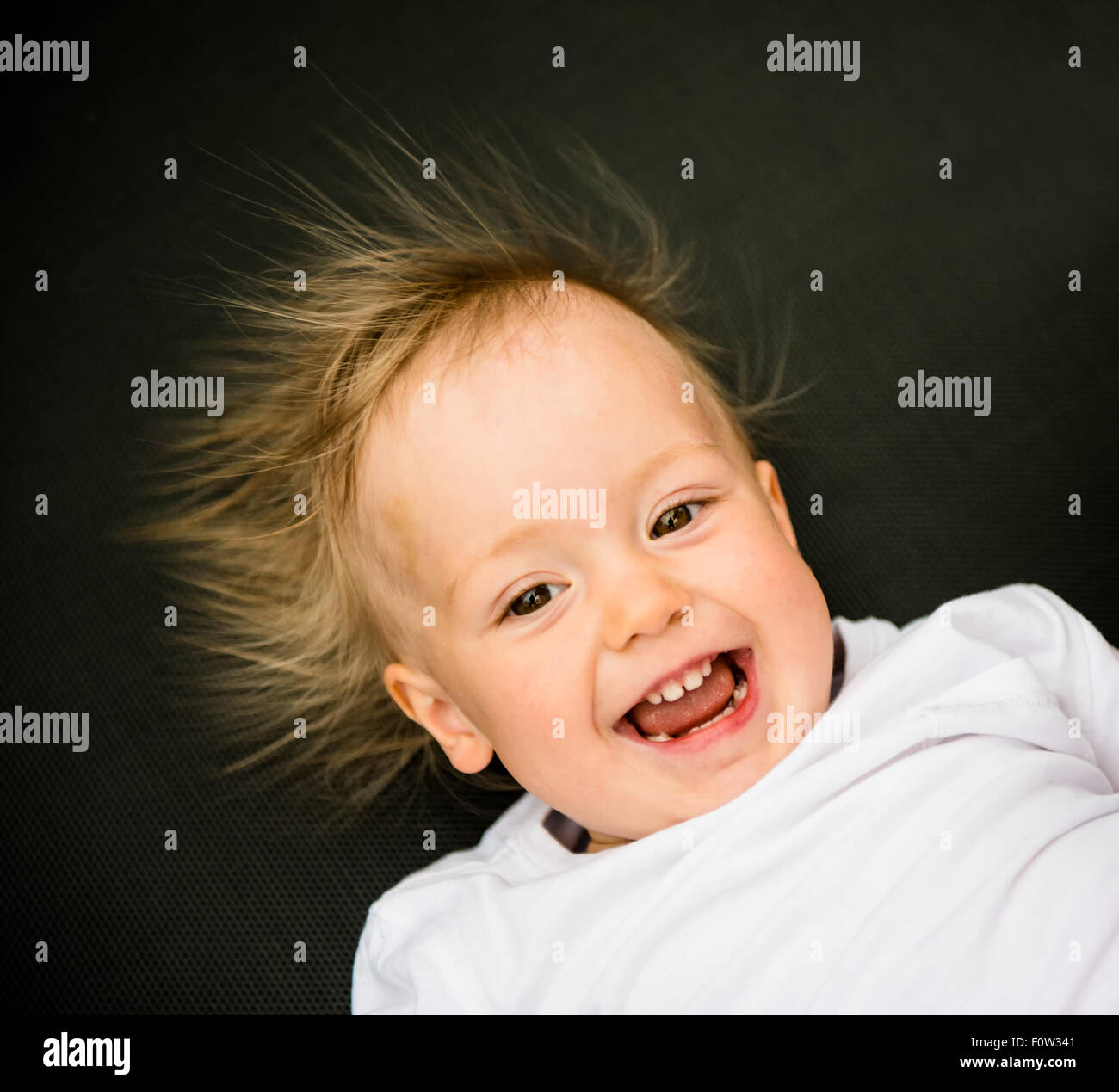 Porträt der lachende Baby mit stehenden Haaren vor statischer Elektrizität Stockfoto