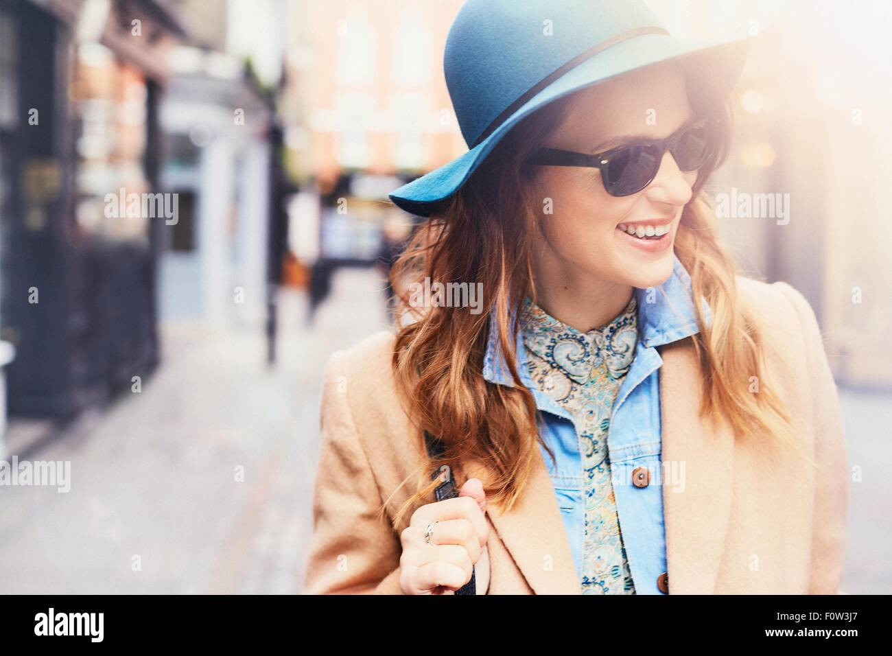Modisch junge weibliche Shopper tragen Filz Hut und eine Sonnenbrille, London, UK Stockfoto