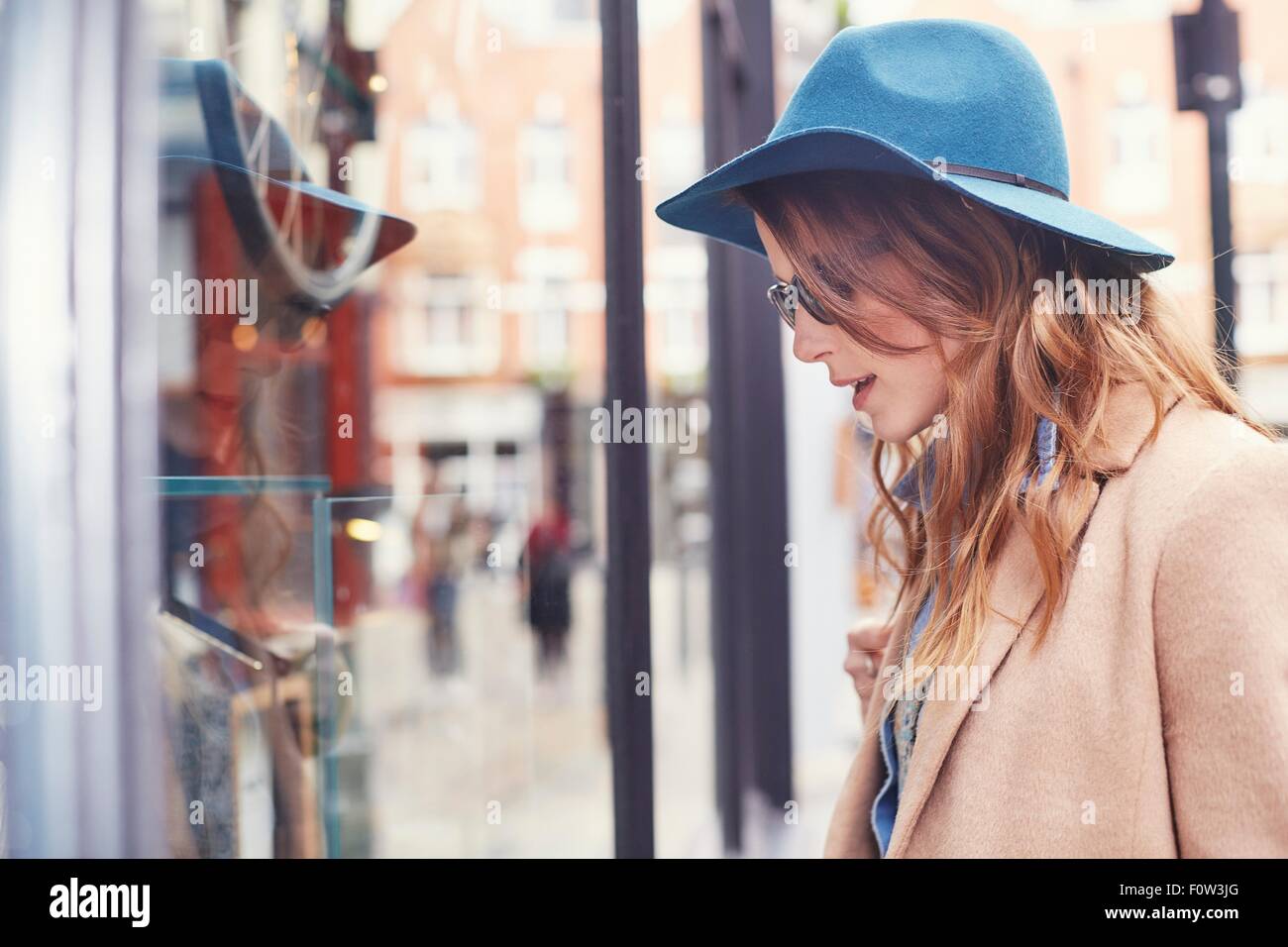 Stilvolle junge weibliche Shopper betrachten Schaufenster, London, UK Stockfoto
