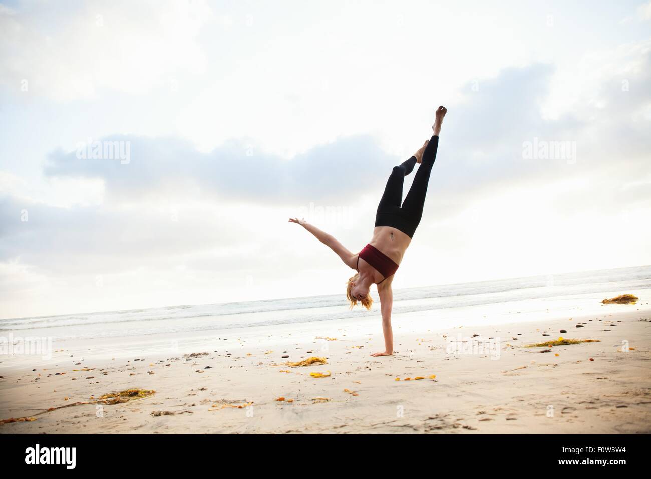 Mitte Erwachsene Frau praktizieren Yoga Stellung am Strand Stockfoto