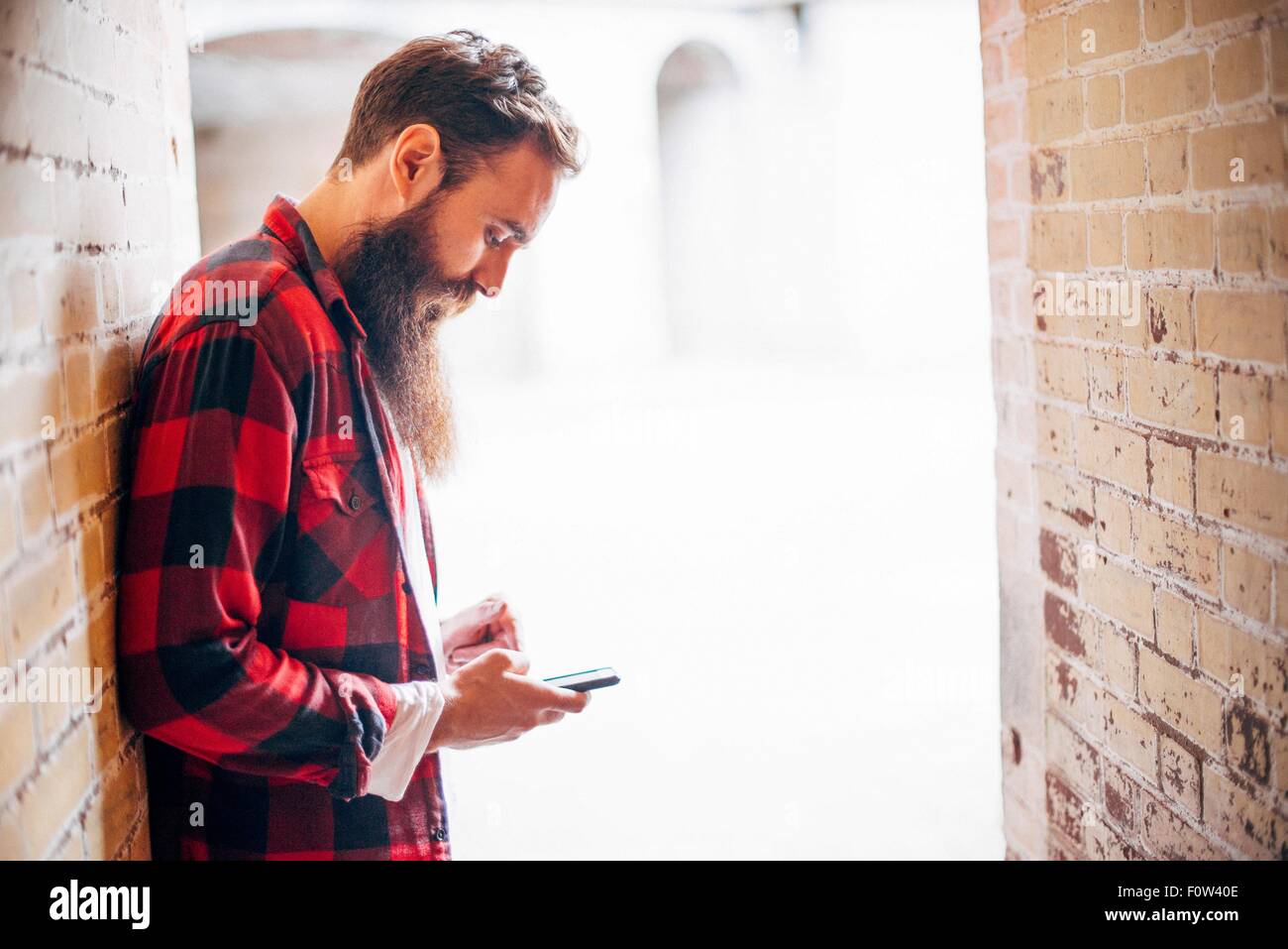 Seitenansicht der Mann mit Bart hält smartphone Stockfoto