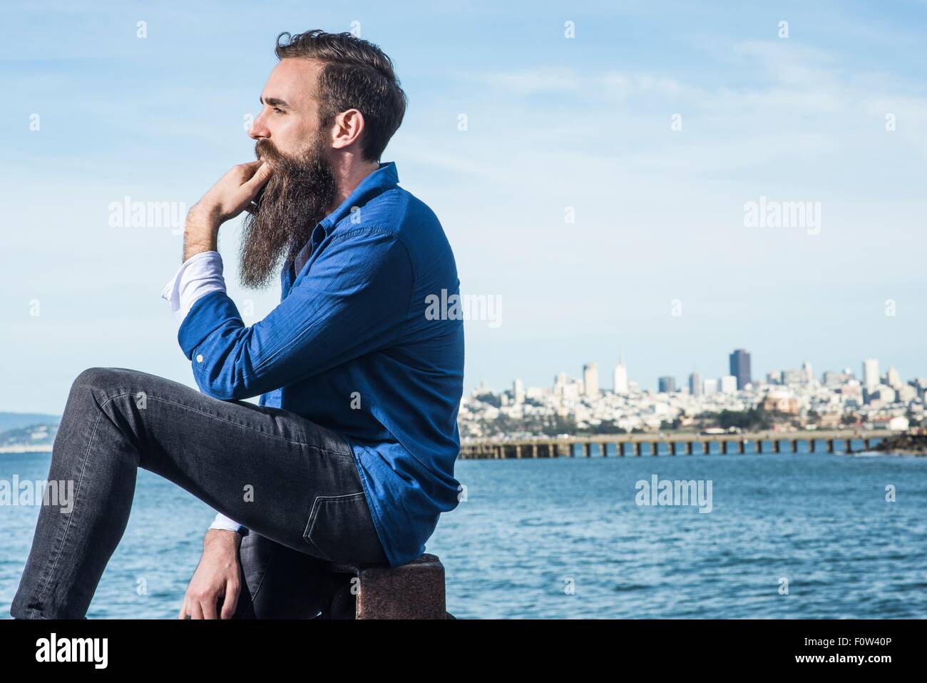 Mann mit Bart sitzt am Hafen Point, San Francisco, Kalifornien, USA Stockfoto