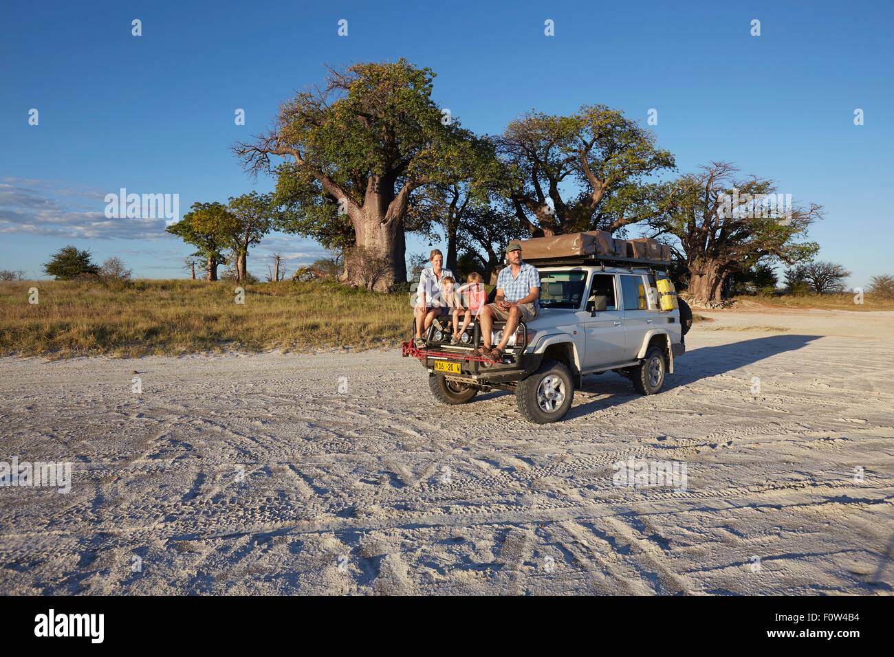 Paar mit Söhnen auf Fahrzeug, Nxai Pan Nationalpark, Kalahari-Wüste, Afrika Stockfoto