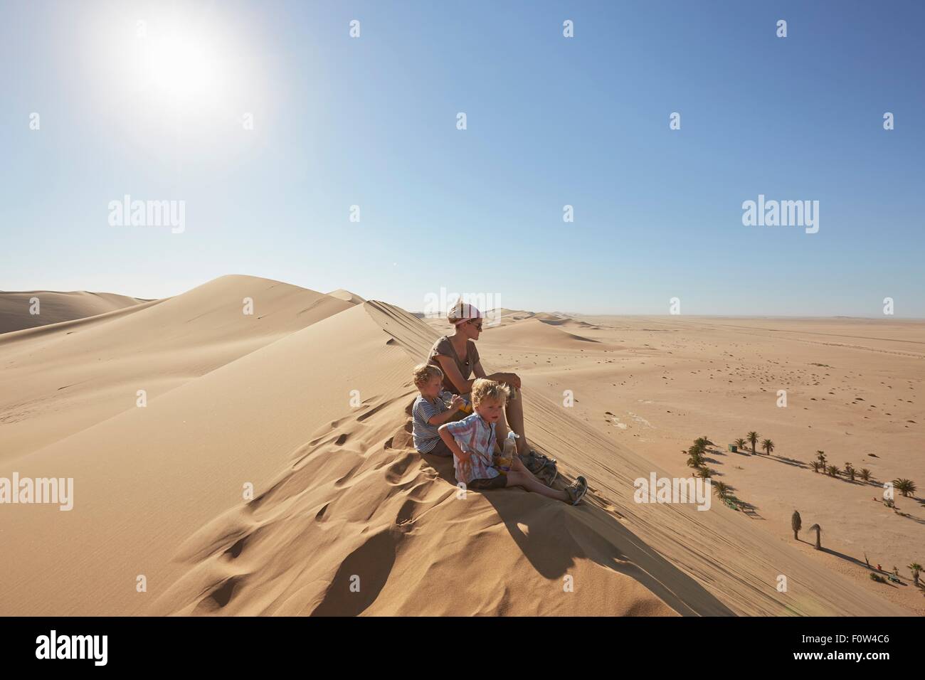Mutter und Söhne sitzen auf Sand Dune, Dune 7, Namib-Naukluft-Nationalpark, Afrika Stockfoto