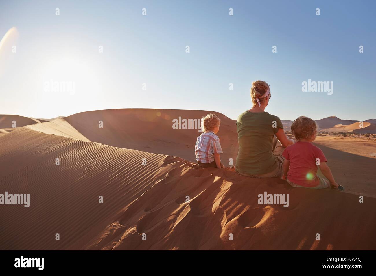 Mutter und Söhne sitzen auf Sanddüne, Namib Naukluft National Park, Namib Wüste, Sossusvlei, Dead Vlei, Afrika Stockfoto