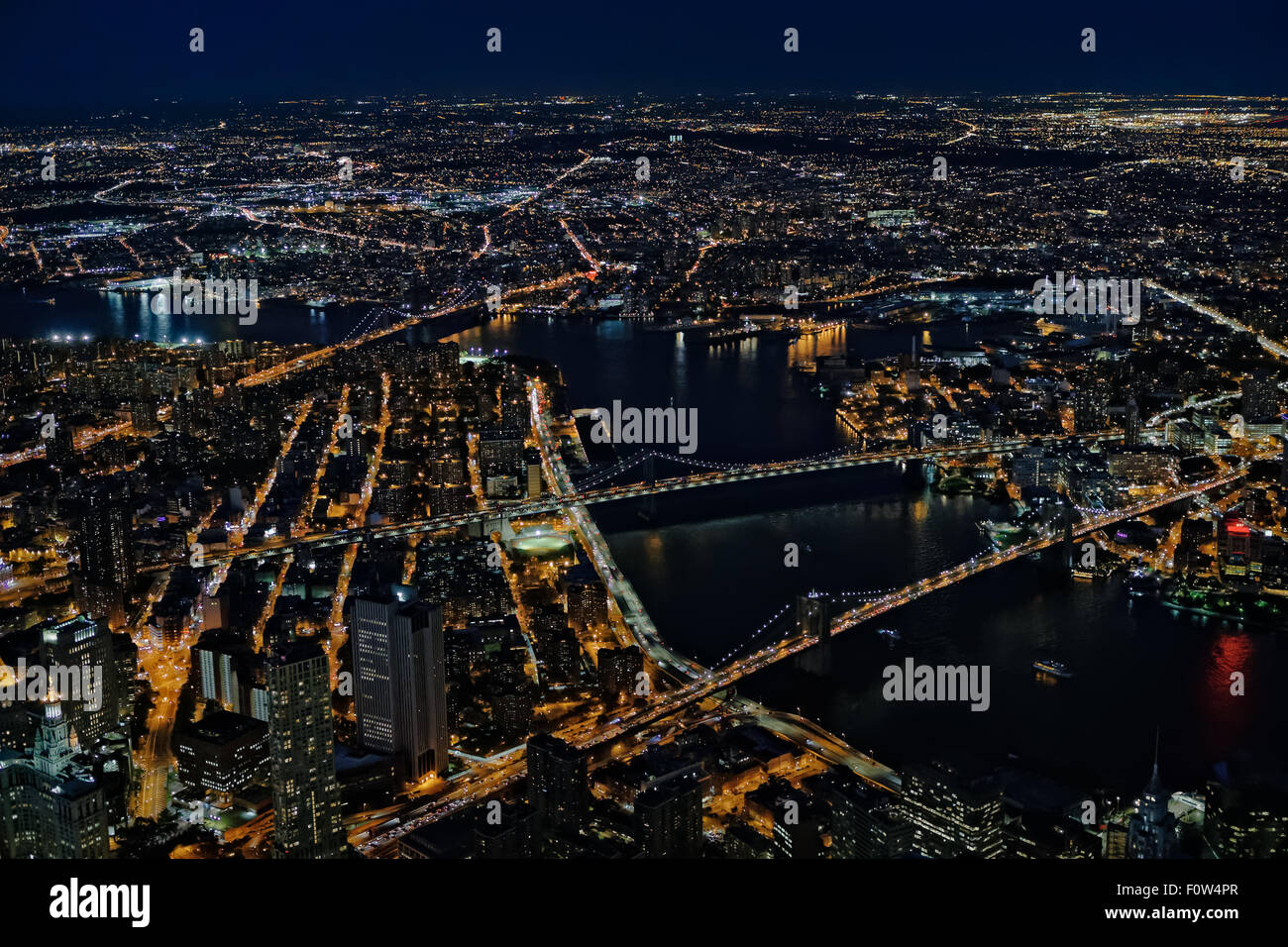 Brooklyn, Manhattan und Williamsburg Brücken Luftaufnahme - ein Blick von oben auf die beleuchtete Lower Manhattan in New York City, die im Stadtbezirk Brooklyn und der Brooklyn, Manhattan und Williamsburg Brücken während der Blauen Stunde der Dämmerung. Stockfoto