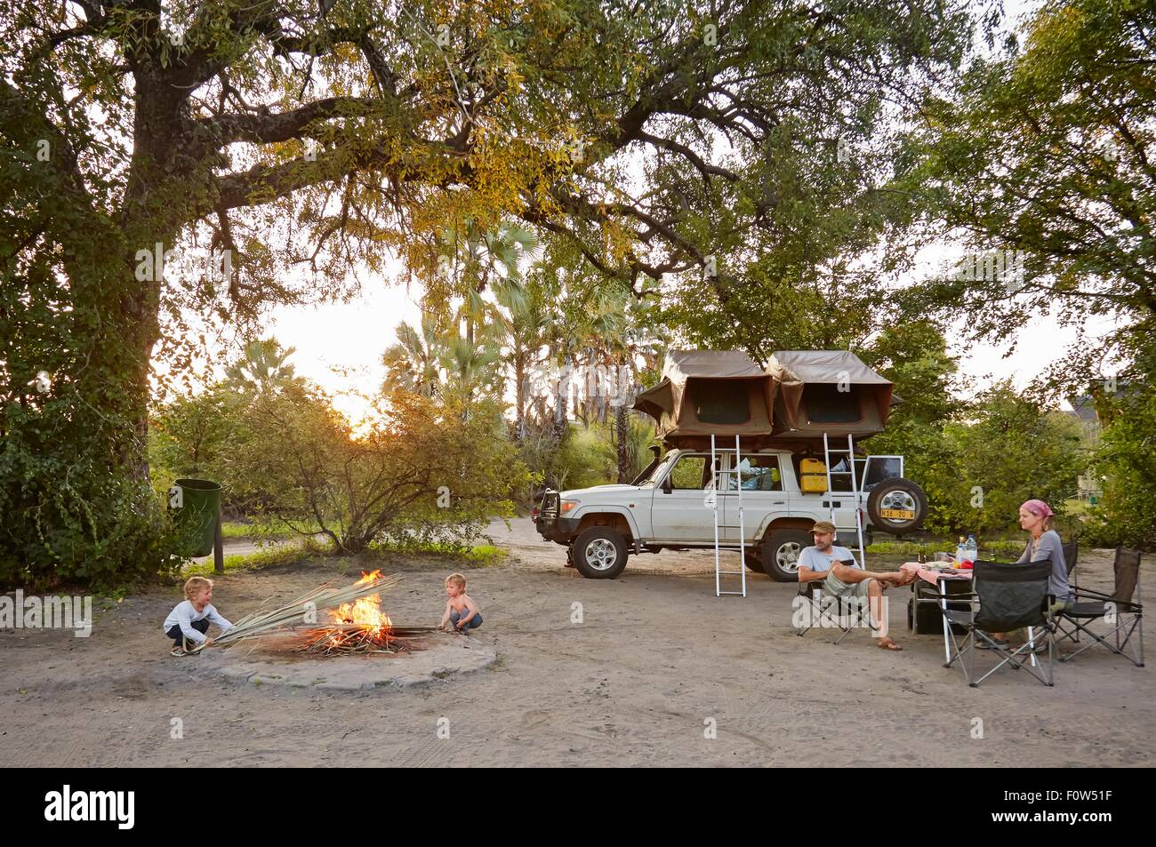 Geländewagen geparkt Familie Entspannung rund um Camp fire, Nata, Makgadikgadi, Botswana Stockfoto