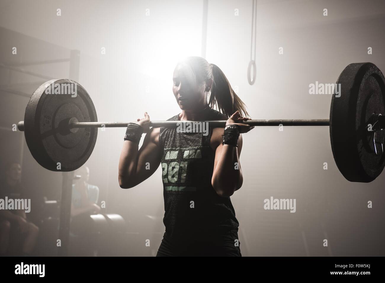 Junge Frau heben Barbell Stockfoto