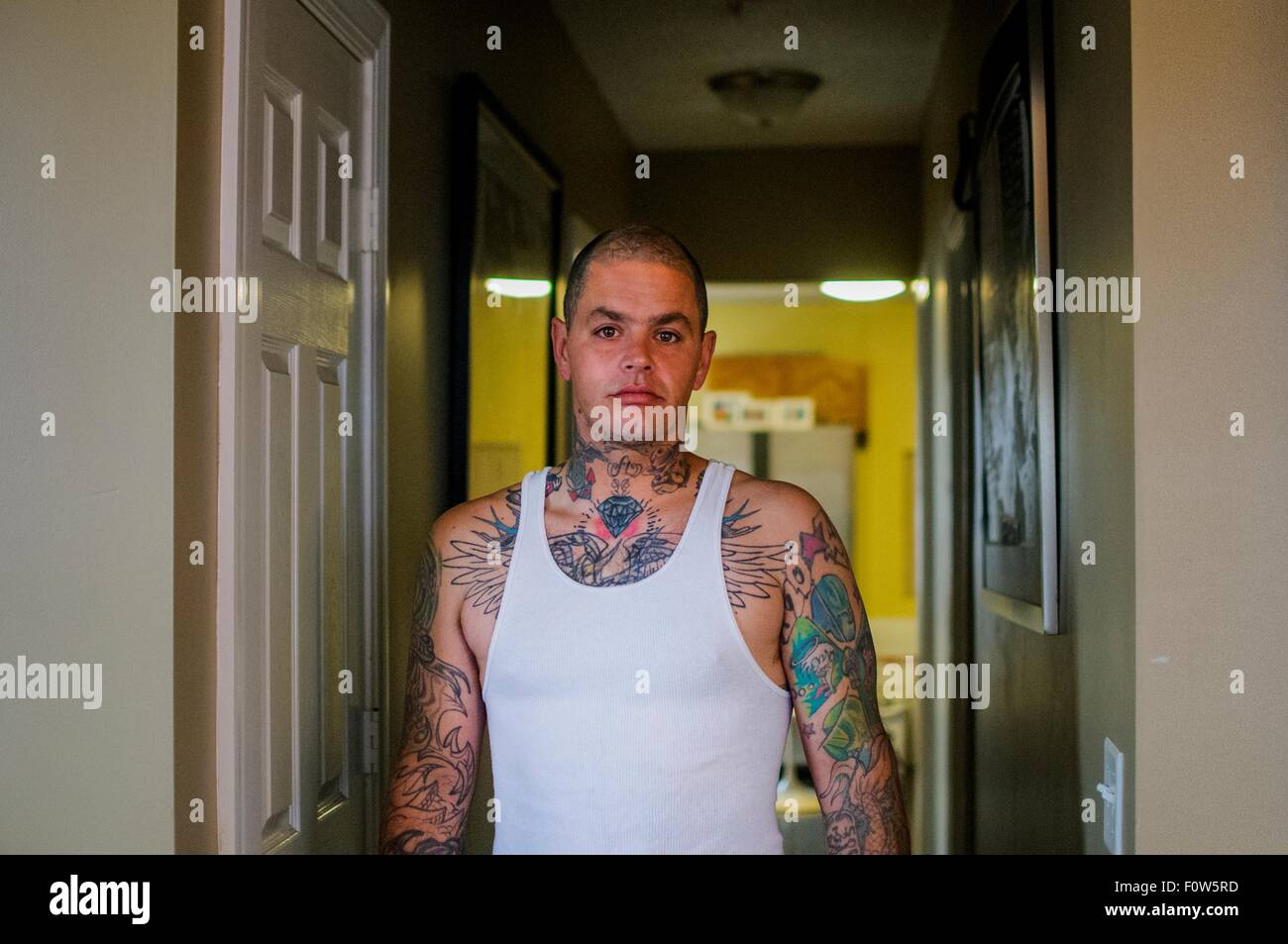 Porträt von Mitte erwachsener Mann mit Tattoos mit Weste Stockfoto