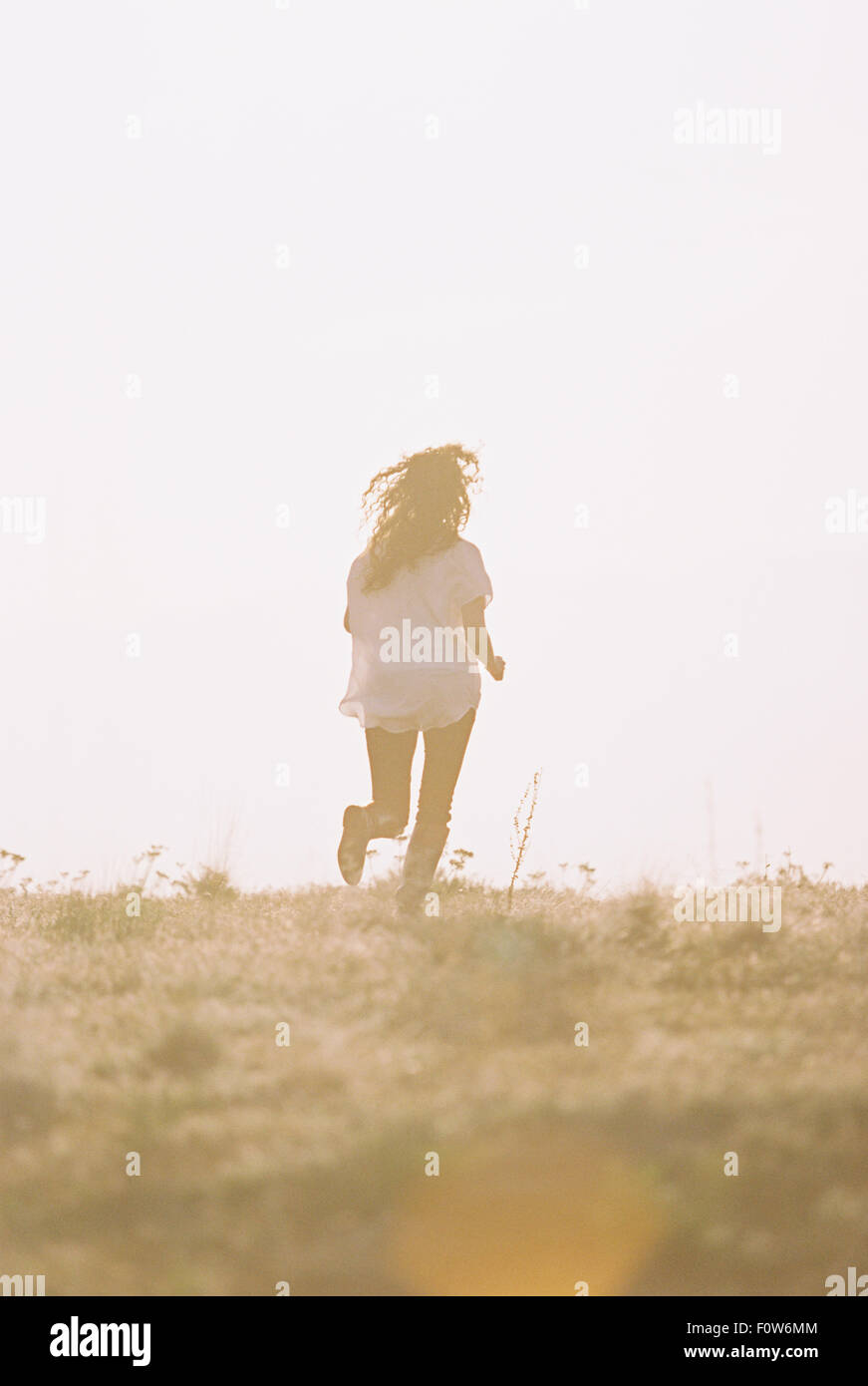 Eine Frau mit ihren langen Haaren, fanning hinter ihr laufen. Stockfoto