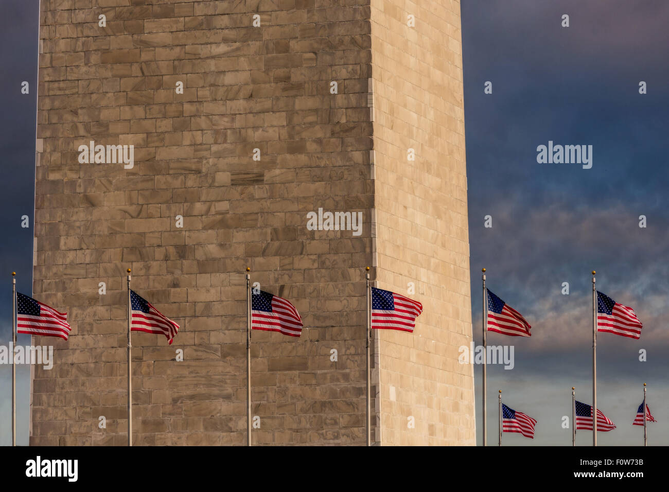 Schließen Sie die Ansicht des unteren Teils des Washington Monuments mit den Vereinigten Staaten von Amerika Flaggen, die rund um das Denkmal. Stockfoto