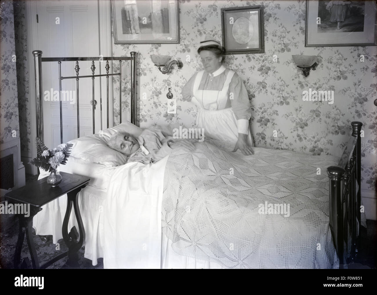 Antikes c1910 Foto einer kranken älteren Frau mit einer Krankenschwester. Standort unbekannt, wahrscheinlich Jamaica Plain (Boston), Massachusetts, New England, USA. Stockfoto