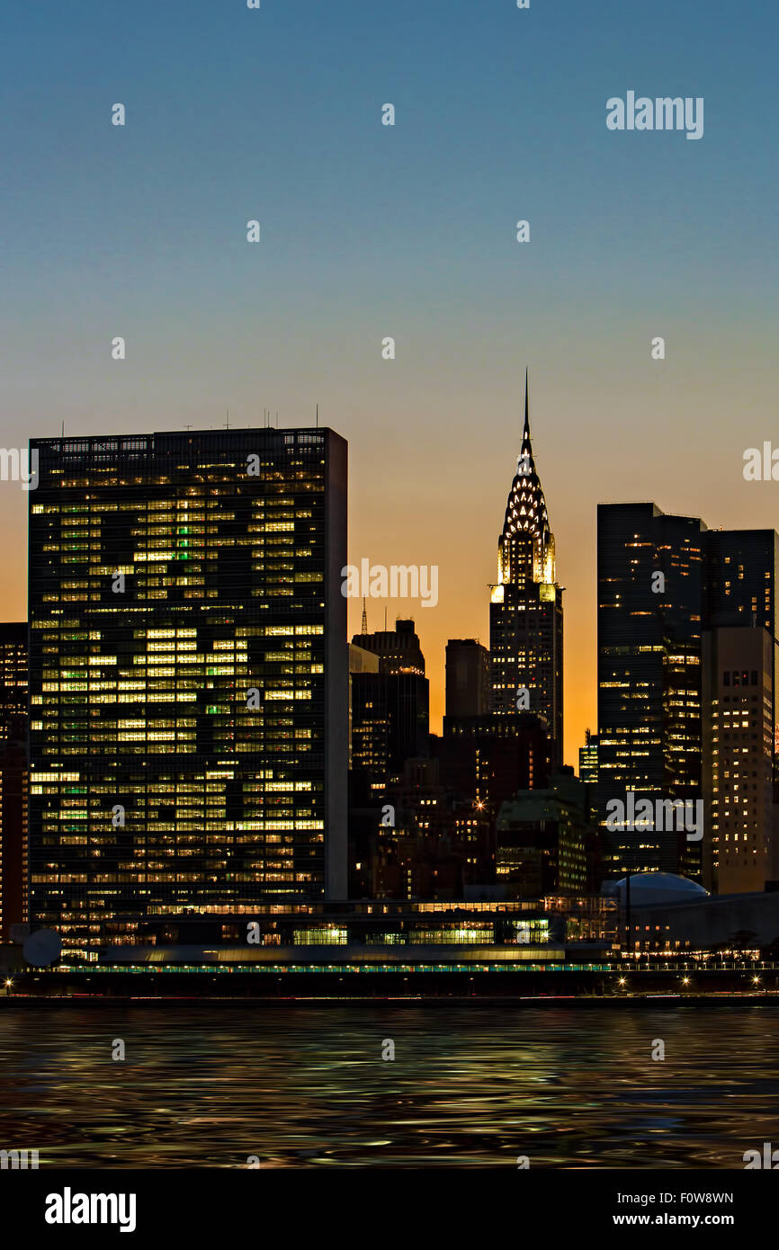 Die untergehende Sonne hinter dem Chrysler Building und das UN-Gebäude in New York City vom Gantry Plaza State Park in Long Island City aus gesehen. Stockfoto