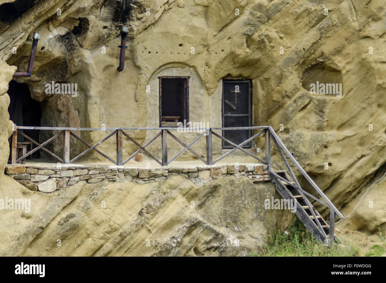 Einzigartige, in Felsen gehauene Wohnung mit Holzdeck in bergiger Landschaft zeigt alte architektonische Techniken Stockfoto