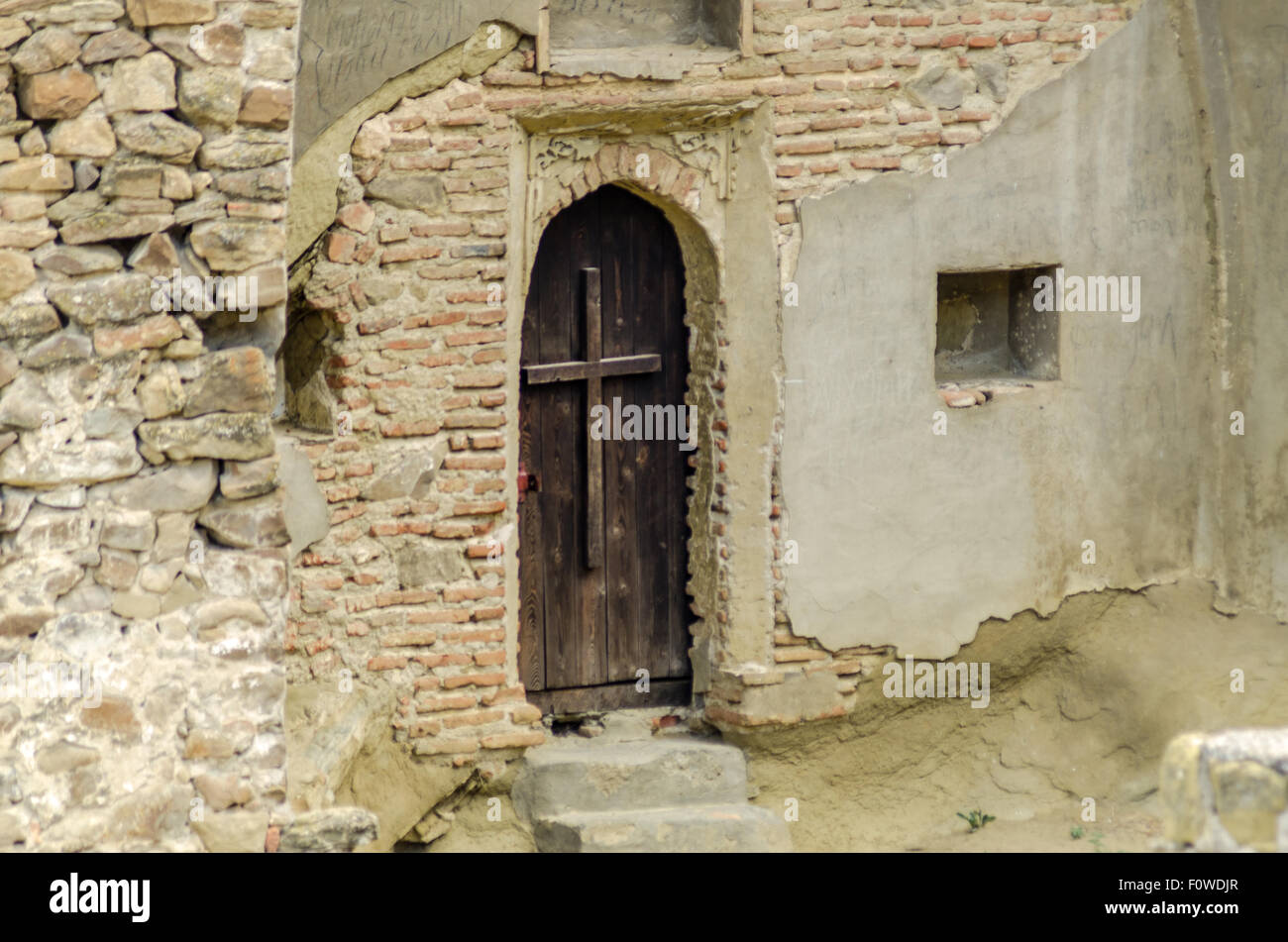 Einzigartige, in Felsen gehauene Wohnung mit Holzdeck in bergiger Landschaft zeigt alte architektonische Techniken Stockfoto
